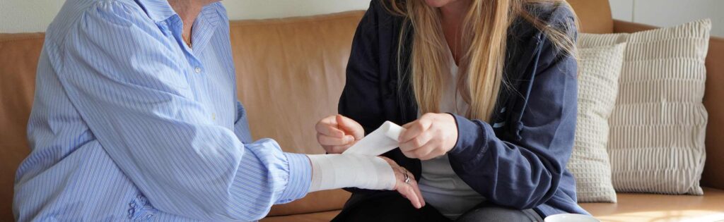 Privat sygepleje i eget hjem: sygeplejerske lægger bandage på klient